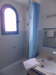 uma casa de banho com um lavatório e um chuveiro em Hotel Alhambra em Cap d'Agde
