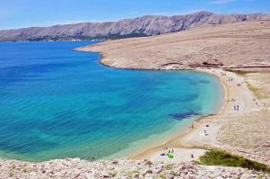 a group of people on a beach near the water at Apartments Niko Metajna, island Pag in Metajna
