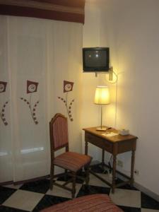 a room with a desk and a chair and a television at Hotel Mediante in Ribadeo