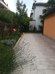 un giardino con passerella in pietra di fronte a una casa di Villa Al Sole a Mestre