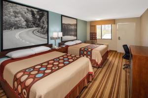 a hotel room with two beds and a large screen at Super 8 by Wyndham Burlington NC in Burlington
