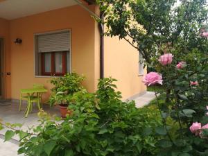 um jardim com flores cor-de-rosa e uma mesa verde em Villa Al Sole em Mestre