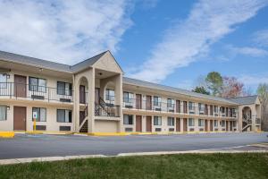 un grand bâtiment avec un parking en face de celui-ci dans l'établissement Super 8 by Wyndham Burlington NC, à Burlington