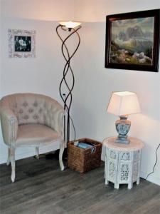 a living room with a chair and a lamp at Garni Villa Tyrol - Adults Only in Merano