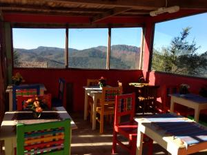 ein Restaurant mit Tischen und Stühlen mit Bergen im Hintergrund in der Unterkunft Pousada Ecologica Vale das Cores in Lavras Novas + 38 Fotos