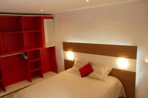 a bedroom with a bed with a red headboard at La Maison Bleue d'Ardèche in Saint-Mélany