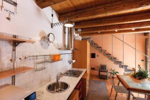 a kitchen with a sink and a table and a staircase at La Casetta in Piazzetta in Cormòns