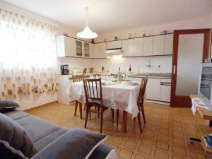a kitchen and dining room with a table and chairs at Apartments Lukoran in Lukoran