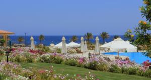 un complejo con jardín y piscina en Royal Brayka Beach Resort, en Abu Dabab