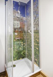 a shower with a glass door in a room at Hotel Ertl in Kulmbach