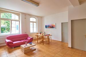 a living room with a red couch and a table at Ferrari Apartment in Interlaken