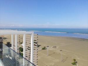 uma vista para a praia a partir da varanda de um edifício em Hotel Madalù em Rimini