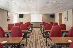 a classroom with red chairs and tables and a whiteboard at Super 8 by Wyndham Chambersburg I-81 in Chambersburg +19 photos