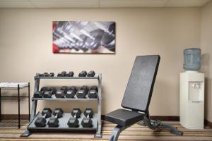 a gym with a chair and a rack of dumbbells at Super 8 by Wyndham Chambersburg I-81 in Chambersburg