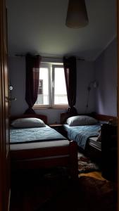 a bedroom with two beds and a window at Porodicni apartman in Herceg-Novi