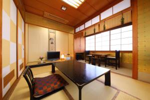 ein Zimmer mit einem Tisch und Stühlen in einem Zimmer in der Unterkunft Onyado Takasago in Ureshino