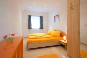 Un dormitorio con una cama amarilla y una mesa en Apart Hofer en Nauders