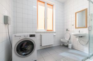 ein weißes Badezimmer mit einer Waschmaschine und einem Waschbecken in der Unterkunft Noclegi Bielpon in Przemyśl
