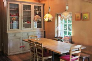 a dining room with a wooden table and chairs at De Volle Maan - Zomerhuis in Sint-Lievens-Houtem
