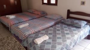 Suítes Centro Praia في فورتاليزا: سريرين يجلسون بجانب بعض في غرفة النوم