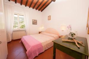 a bedroom with a bed and a table and a window at L'Oleandro Colle D'Orano in La Guardia