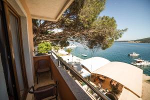 ein Balkon eines Hauses mit Blick auf das Wasser in der Unterkunft Hotel Fiammanti in Herceg-Novi