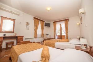 ein Hotelzimmer mit zwei Betten und einem Kamin in der Unterkunft Hotel Fiammanti in Herceg-Novi