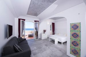 uma sala de estar com uma cama, um sofá e um espelho em Villa Bossa em Amalfi