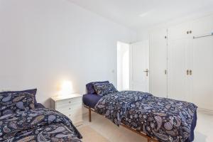 een slaapkamer met 2 bedden en een nachtkastje bij Mi Jardin in Benalmádena