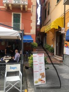 a man sitting at a table in front of a restaurant at Appartamento con splendida vista - Lerici Centro in Lerici