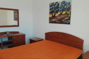 a bedroom with a bed and a painting on the wall at Luka Kokić Apartments in Podgora