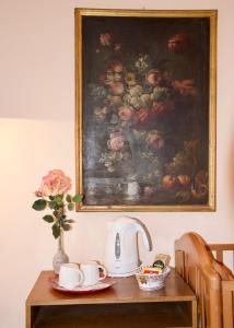 a table with a painting and a tea kettle on it at M&G Apartment in Florence