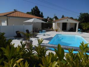a villa with a swimming pool and a house at Chambres d'hôtes LA COZY in Cozes +9 photos
