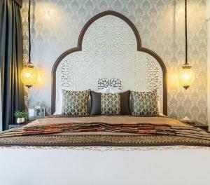 un letto con una grande testiera in una camera da letto di Palette The Grand Morocc Hotel a Mae Rim