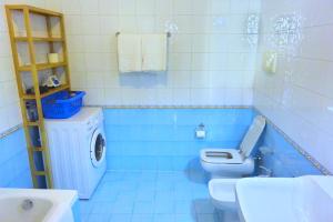 a blue bathroom with a toilet and a sink at Ca' Nova Apartments in Bassano del Grappa +36 photos
