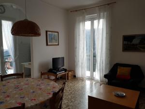 a living room with a dining room table and a television at Villa delle Rose in Chiavari
