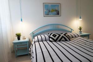 łóżko z czarno-białą kołdrą i dwoma stołami w obiekcie Eleatica Holiday Apartment w mieście Ascea