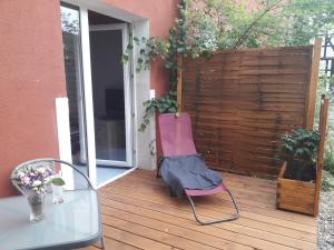 a pink chair sitting on a deck with a table at 1 Zimmer Appartment in Springe