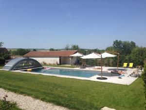 a swimming pool in a yard with an umbrella at Le Gîte de Saint Phal in Saint-Phal