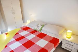 1 dormitorio con 1 cama con manta roja y blanca a cuadros en Villa Niko en Costa Paradiso