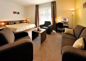une chambre d'hôtel avec un lit et deux canapés dans l'établissement Melrose Apartments 2, à Bratislava