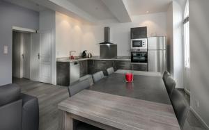 a kitchen with a table and chairs and a kitchen with a refrigerator at Paradis Doré in LʼIsle-sur-la-Sorgue