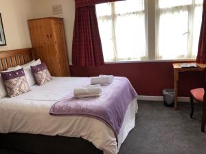 a bedroom with a bed with two towels on it at The Woolaston Inn in Lydney