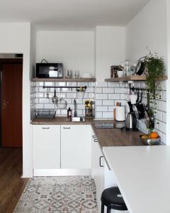 uma cozinha com armários brancos e uma bancada em Studio apartman Knežija em Zagreb