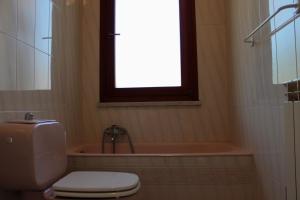 a bathroom with a tub and a toilet and a window at Villa Antonini in Lerici