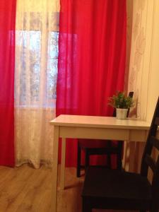 エカテリンブルクにあるMalysheva 125aのテーブルと赤いカーテン付きの部屋
