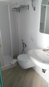 a white bathroom with a toilet and a sink at La Sirenetta Park Hotel in Stromboli