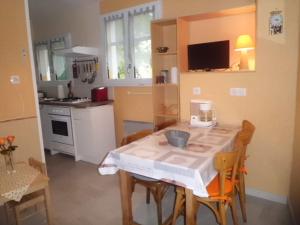 eine Küche mit einem Tisch und Stühlen sowie eine Küche mit einem Herd in der Unterkunft Maison des Bains in Allevard