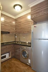 a kitchen with a washer and a white refrigerator at Уютная квартира около медицинского центра Астхик! in Yerevan