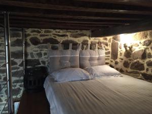 una camera con un letto in una parete in pietra di Le 1684 a Saint Malo